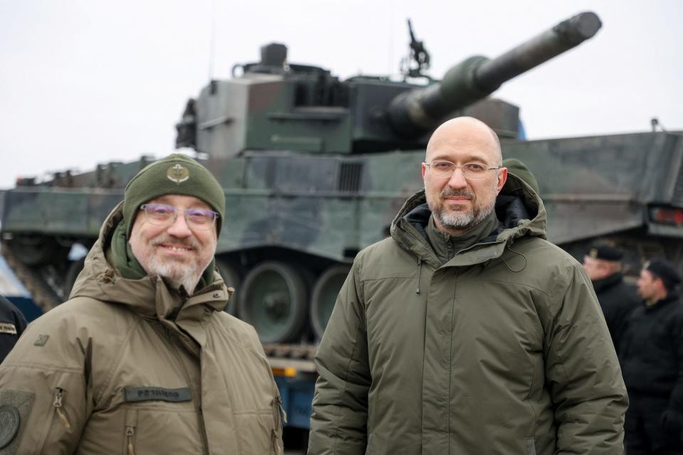 Ukraine's prime minister and defense minister  stand next to the first Leopard 2 tanks delivered from Poland on a day of the first anniversary of Russia's attack on Ukraine, in an undisclosed location, Ukraine February 24, 2023.