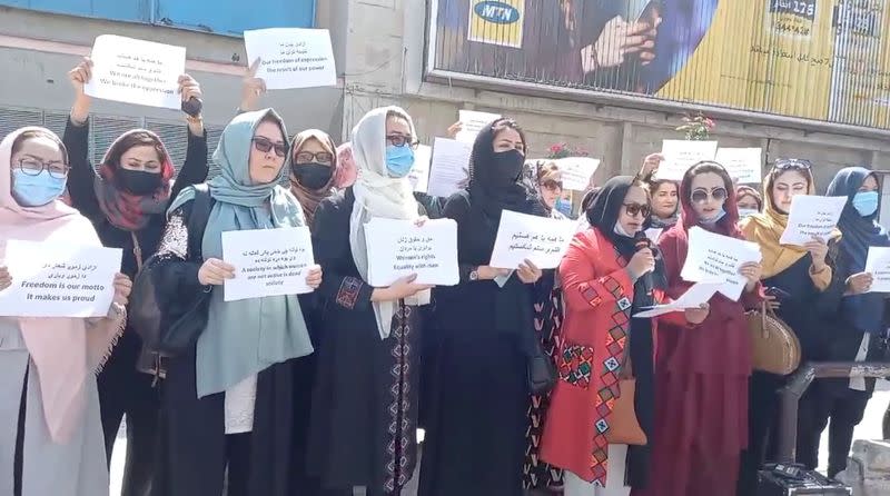 Women hold placards as they protest in Kabul