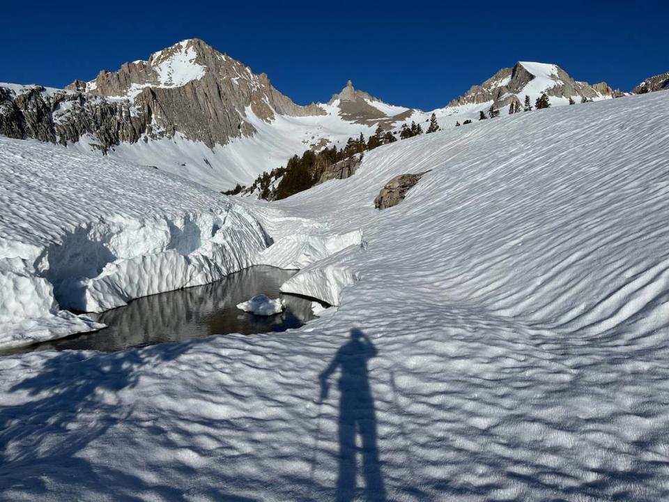 The morning shadow of Clovis ski mountaineer Ryan Soares points toward thumb-like Milestone Mountain in Sequoia National Park, the midway point of the Sierra High Route ski tour. Soares claimed the route’s Fastest Known Time of 18 hours, 17 minutes on May 25, 2023.