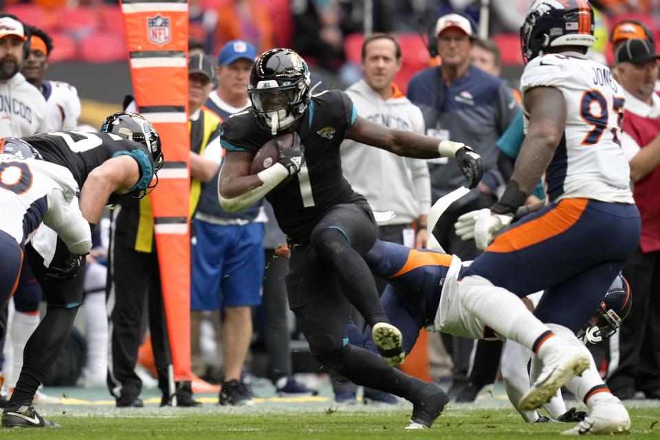 Jacksonville Jaguars running back Travis Etienne Jr. (1) is tackled during the NFL football game between Denver Broncos and Jacksonville Jaguars at Wembley Stadium London, Sunday, Oct. 30, 2022. (AP Photo/Kirsty Wigglesworth)