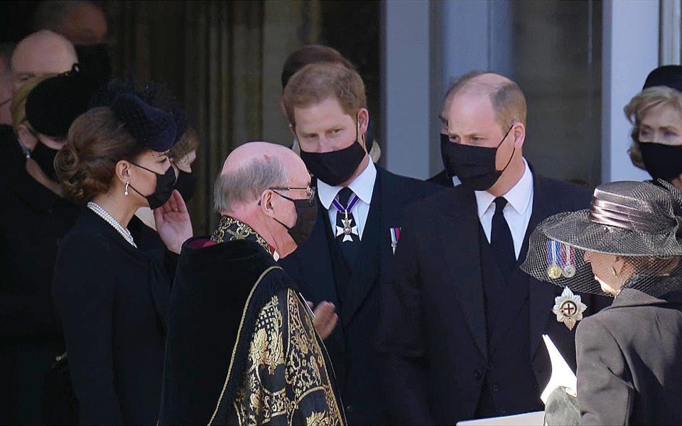 Kate with Harry and William as they talk to the Dean of Windsor after the funeral service  - Pixel