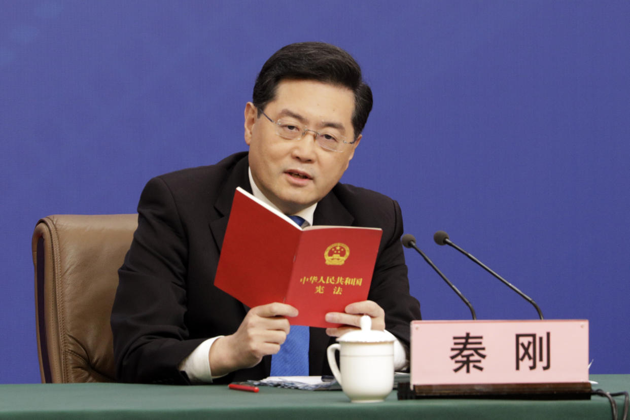 Qin Gang, China's foreign minister, speaks while holding a copy of the constitution during a news conference in Beijing in March.