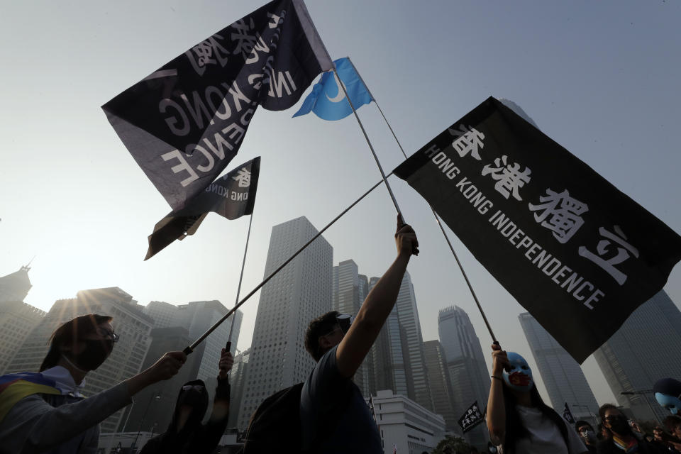 People hold flags during a rally to show support for Uighurs and their fight for human rights in Hong Kong, Sunday, Dec. 22, 2019. Thousands of demonstrators attended a rally to protest against China's policy about Uighur minority. (AP Photo/Lee Jin-man)