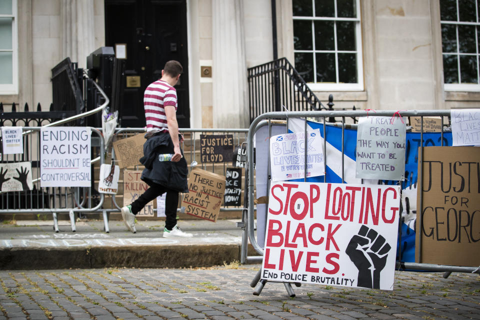 <i>Protest signs posted outside the U.S. Consulate General in Edinburgh, Scotland, in response to the police killing of George Floyd. One reads: "Stop looting Black lives. End police brutality." </i>