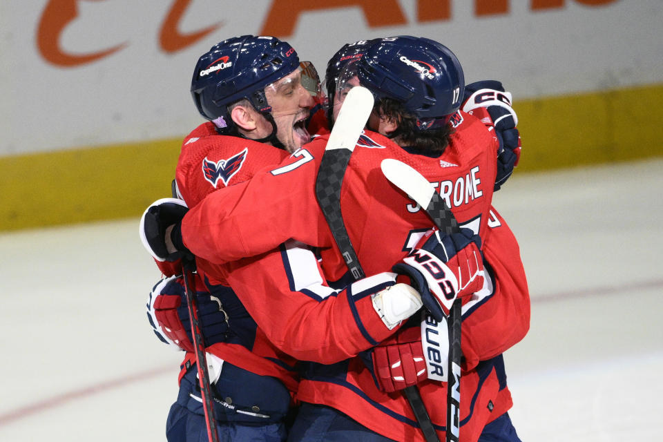 Washington Capitals left wing Alex Ovechkin, left, celebrates his goal with center Dylan Strome (17) and others in the overtime of an NHL hockey game against the Philadelphia Flyers, Wednesday, Nov. 23, 2022, in Washington. The Capitals won 3-2 in overtime. (AP Photo/Nick Wass)