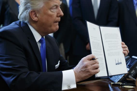 El presidente Donald Trump muestra su orden ejecutiva para impulsar elproyecto de oleoducto Dakota Access. (AP)