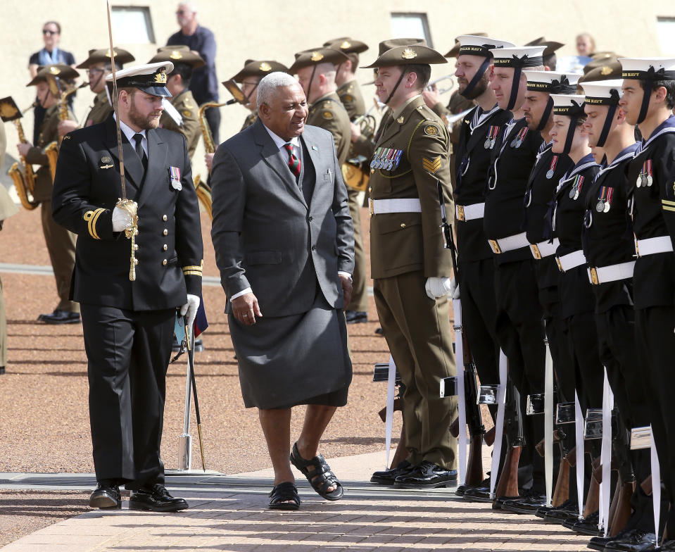 Fiji's Prime Minister Voreqe Bainimarama, center, inspects an honor guard outside Parliament House in Canberra, Australia, during his official welcome to the Australian capital bon Monday, Sept. 16, 2019. Bainimarama visited Canberra on the last days of his Australian visit that started in Sydney on Thursday. (AP Photo/Rod McGuirk)