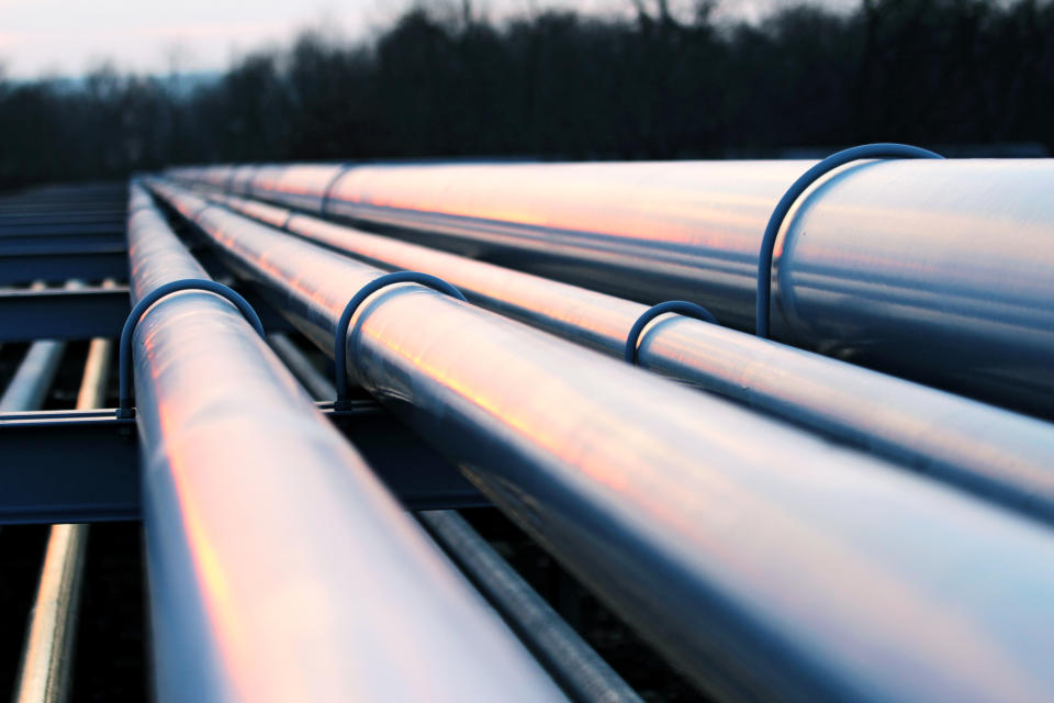 Several pipelines extending into the distance at dusk.