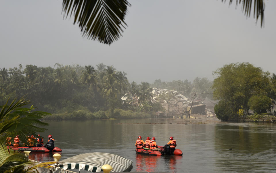 Fire and rescue personnel look at the debris from their boats after water-front residential apartment Alpha Serene was demolished using controlled implosion in Kochi, India, Saturday, Jan. 11. 2020. Authorities in southern Kerala state on Saturday razed down two high-rise luxury apartments using controlled implosion in one of the largest demolition drives in India involving residential complexes for violating environmental norms. (AP Photo/R S Iyer)