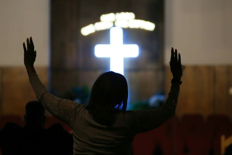 A woman raises her arms in prayer at a morning service for singer Aretha Franklin at the New Bethel Baptist Church on August 15, 2018 in Detroit, Michigan