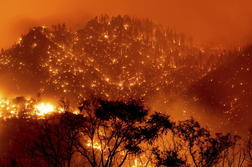 In this long exposure photo, embers light up hillsides as the Dixie fire burns near Milford.