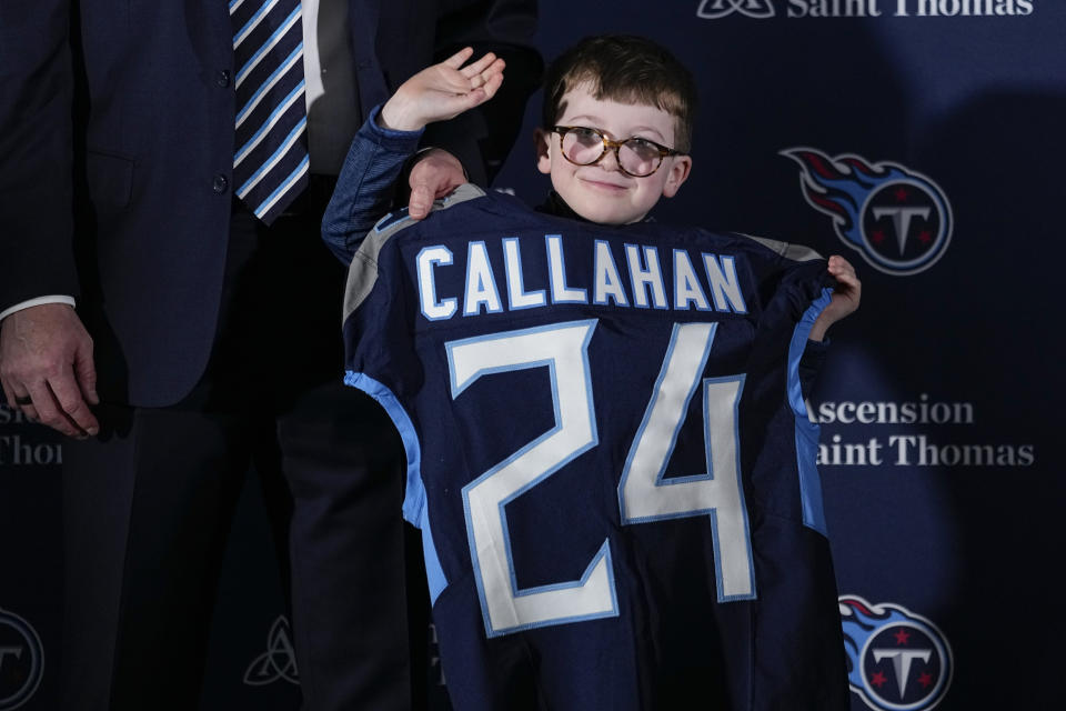Ronan Callahan, son of Tennessee Titans new head football coach Brian Callahan, waves to photographers after an introductory news conference for his father at the NFL team's training facility Thursday, Jan. 25, 2024, in Nashville, Tenn. (AP Photo/George Walker IV)