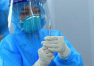 A health worker prepares a dose of AstraZeneca COVID-19 vaccine at Hospital for Tropical Diseases in Hanoi, Vietnam Monday, March 8, 2021. Vietnam has started the vaccination campaign with a hope to inoculate half of the population of 96 millions against COVID-19 by the end of the year. (AP Photo/Hau Dinh)