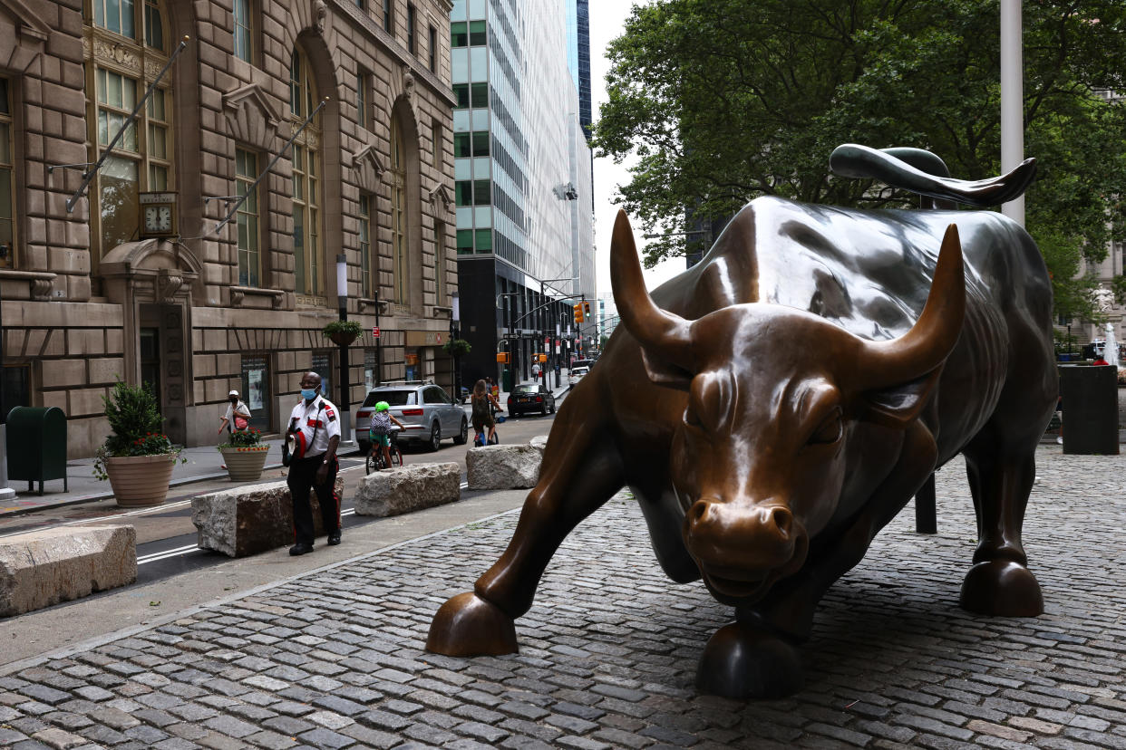 NEW YORK, NEW YORK - JULY 23: People walk along Broadway as they pass the Wall Street Charging Bull statue on July 23, 2020 in New York City. On Wednesday July 22, the market had its best day in 6 weeks. (Photo by Michael M. Santiago/Getty Images)