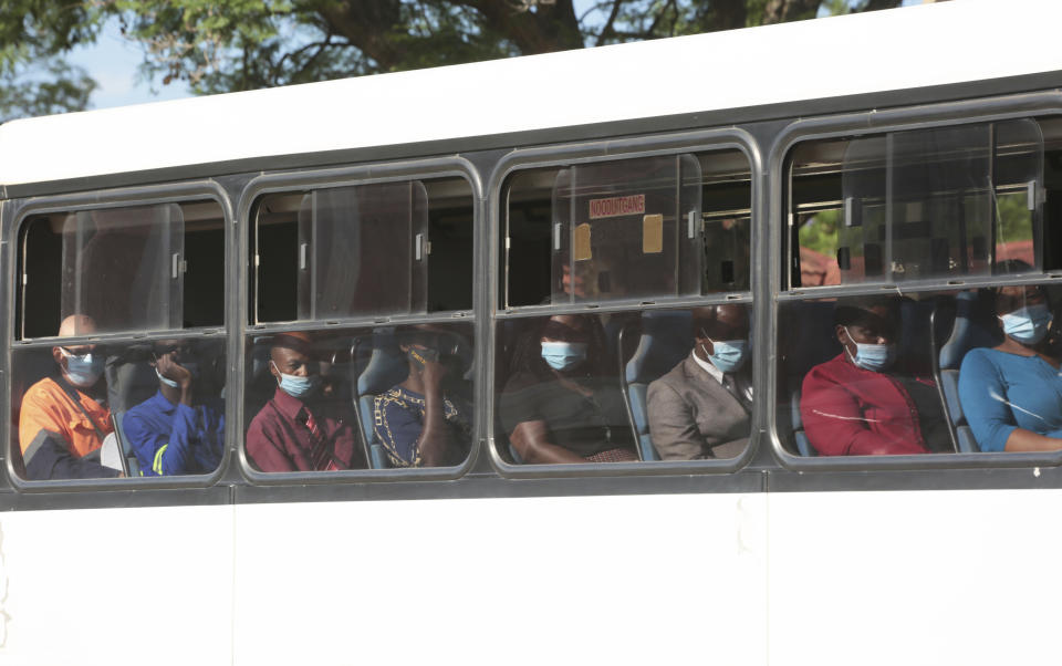 People wear face masks to curb the spread of COVID-19 on a bus in Harare, Zimbabwe, Monday, Nov, 29, 2021. The World Health Organisation has urged countries not to impose flight bans on southern African countries due to concerns over the new omicron variant. (AP Photo/Tsvangirayi Mukwazhi)