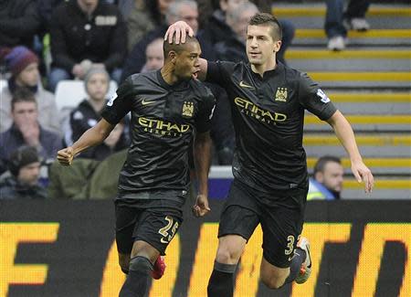 Manchester City's Fernandinho (L) celebrates scoring a goal against Swansea City with Matija Nastasic during their English Premier League soccer match at the Liberty Stadium in Swansea, Wales, January 1, 2014. REUTERS/Rebecca Naden