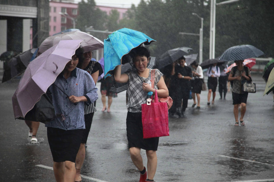 Pedestrians shield themselves from wind and rain brought by Typhoon Lingling Saturday, Sept. 7, 2019, in Pyongyang, North Korea. The typhoon passed along South Korea’s coast has toppled trees, grounded planes and caused at least two deaths before making landfall in North Korea. (AP Photo/Jon Chol Jin)