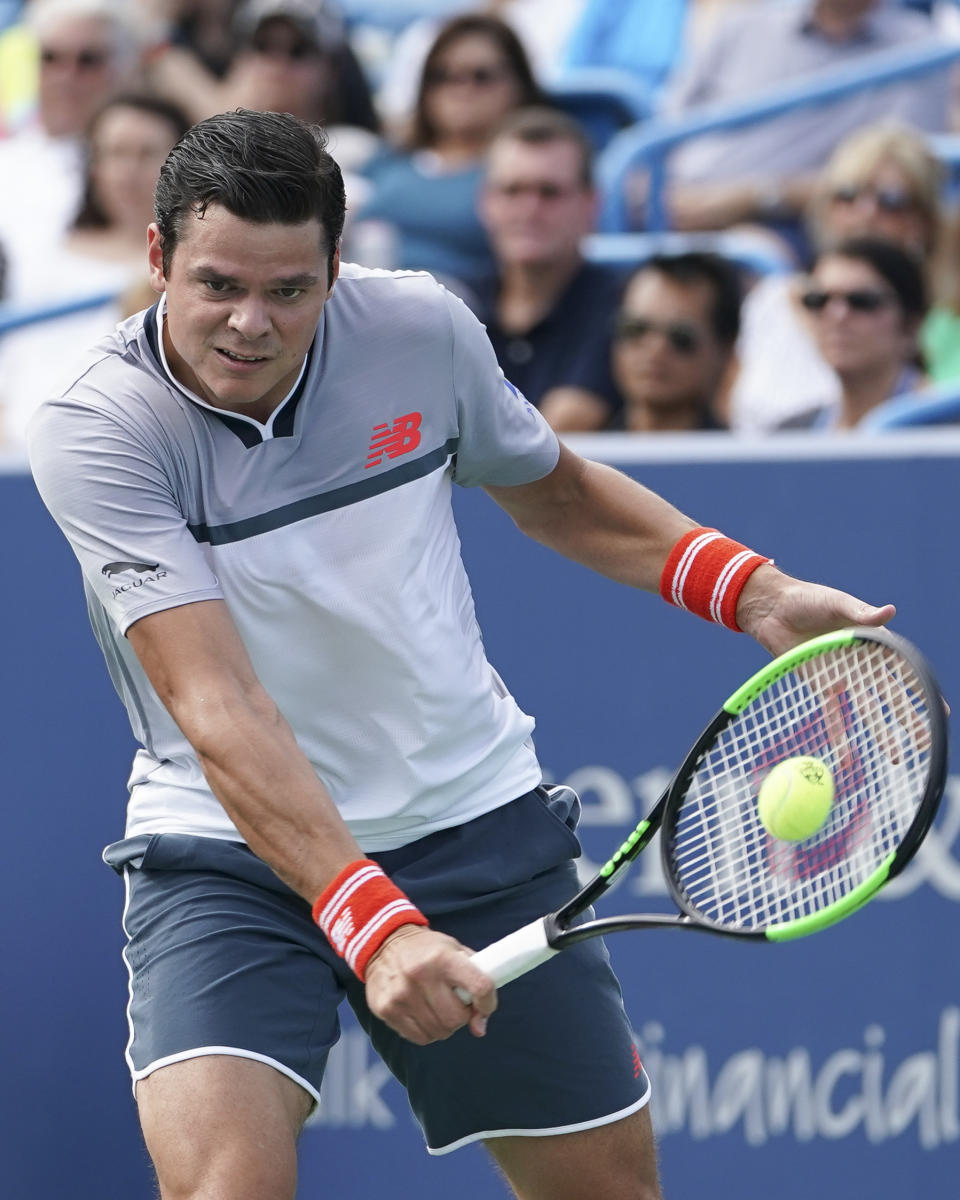 Milos Raonic, of Canada, returns to Novak Djokovic, of Serbia, at the Western & Southern Open tennis tournament, Friday, Aug. 17, 2018, in Mason, Ohio. (AP Photo/John Minchillo)