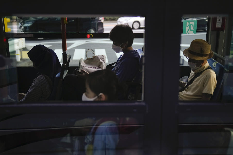 Commuters sit in a bus ahead of the 2020 Summer Olympics, Friday, July 16, 2021, in Tokyo. (AP Photo/Jae C. Hong)