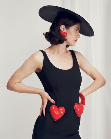 <p>Emma Anderson</p> Moschino dress, earrings, and chapeau.