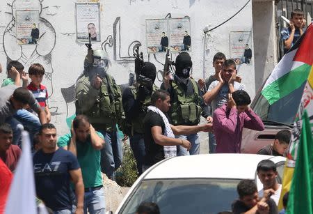 Palestinian militants fire weapons in the air during the funeral of Palestinian youth Laith al-Khaldi near the West Bank city of Ramallah August 1, 2015. REUTERS/Mohamad Torokman