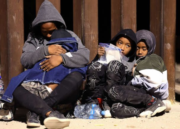 PHOTO: Immigrants seeking asylum in the United States wait as they are processed by U.S. Border Patrol agents in the early morning hours after crossing into Arizona from Mexico on May 10, 2023 in Yuma, Ariz. (Mario Tama/Getty Images)