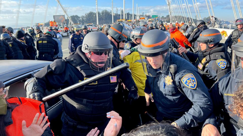 Police officers clear protesters blocking the San Francisco-Oakland Bay Bridge while demonstrating against the APEC summit Thursday, Nov. 16, 2023, in San Francisco. (AP Photo/Noah Berger)