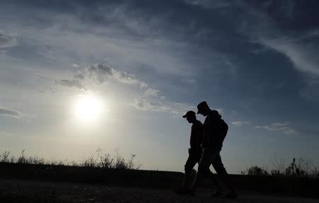 Two migrants walk on the Serbian side of the border near Sid, Croatia September 16, 2015. REUTERS/Antonio Bronic