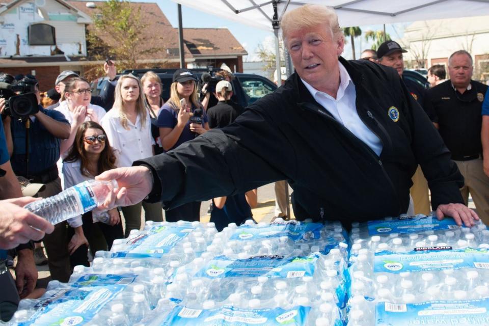 US President Donald Trump hands out bottles of water as he tours damage from Hurricane Michael (AFP/Getty Images)