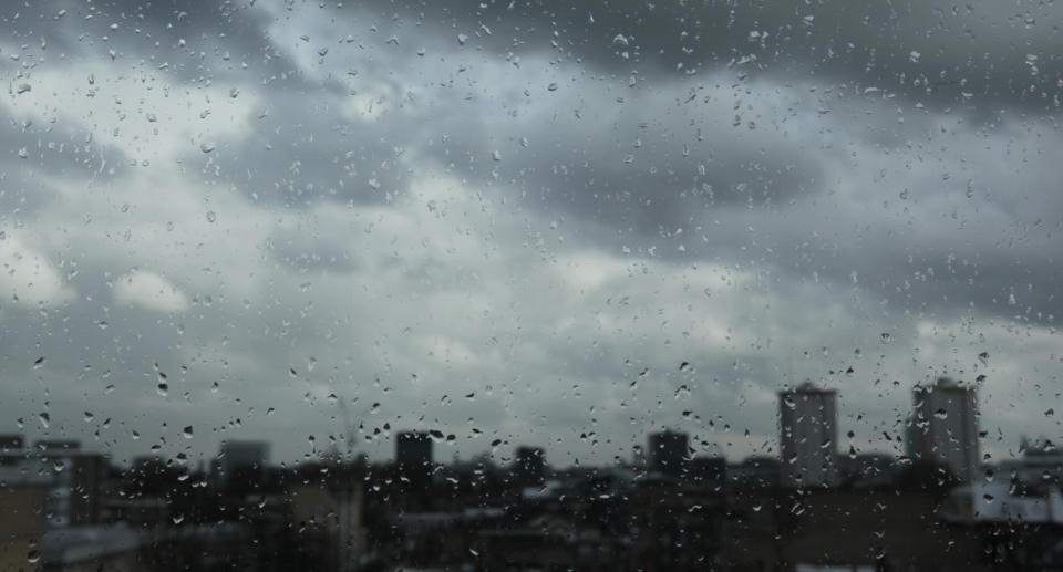 Rain falls on buildings.