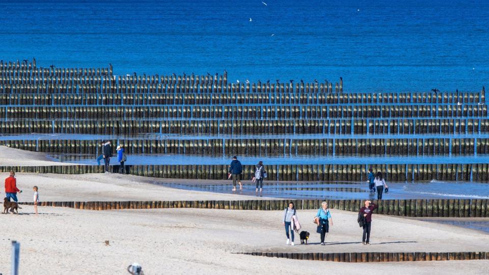 Spaziergänger am Strand von Koserow auf der Ostseeinsel Usedom.