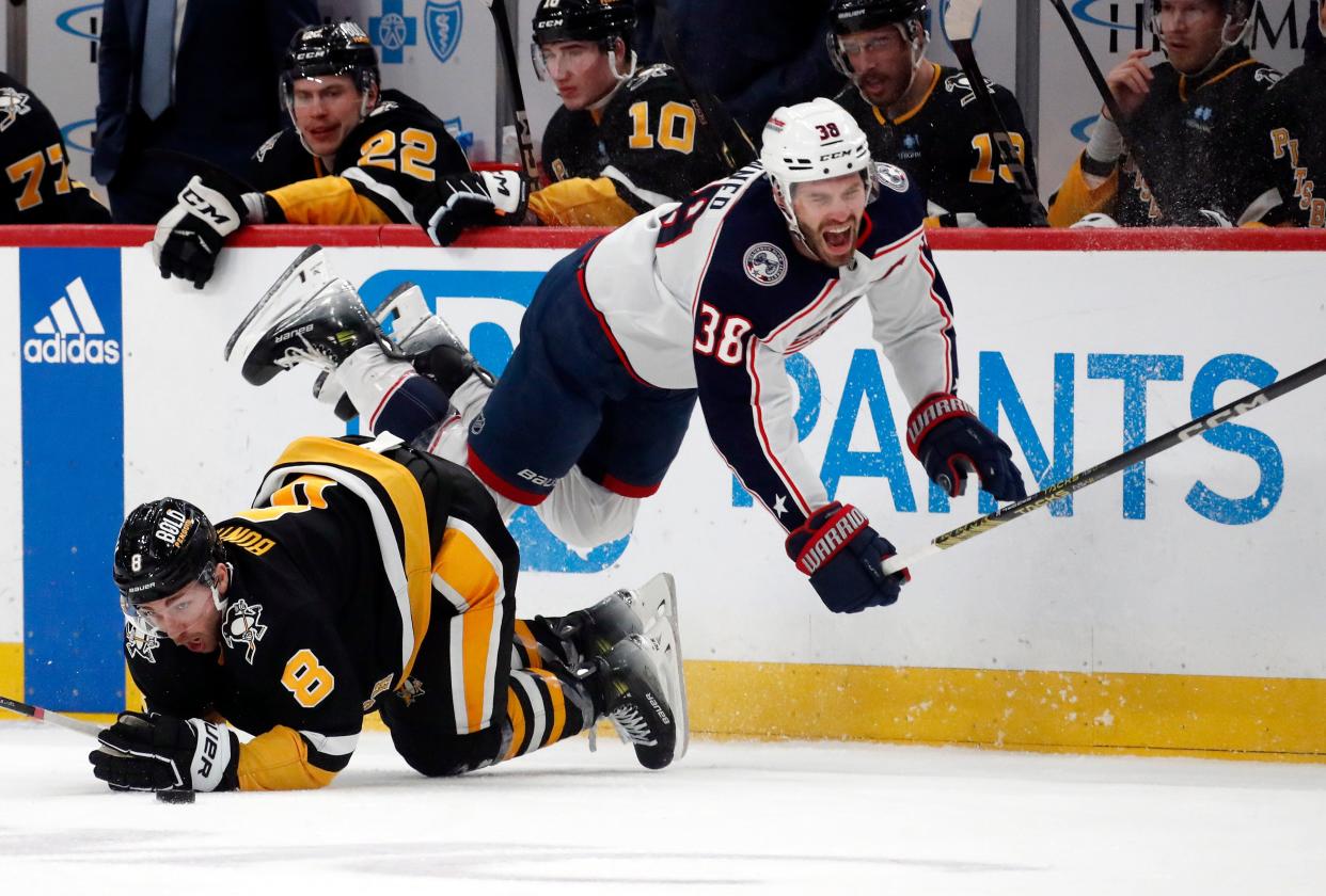 Mar 28, 2024; Pittsburgh, Pennsylvania, USA; Pittsburgh Penguins left wing Michael Bunting (8) upends Columbus Blue Jackets center Boone Jenner (38) during the second period at PPG Paints Arena. Mandatory Credit: Charles LeClaire-USA TODAY Sports