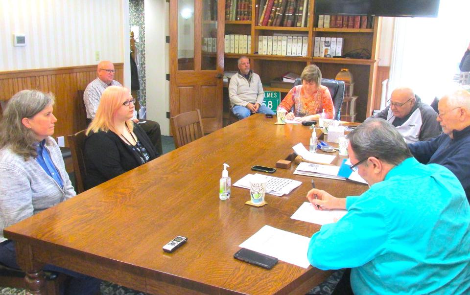 Representativces from OneEighty Kate Abruzzino (from left) and intern Nicole Golubsk look on as Holmes County Commissioner Joe Miller reads a proclamation declaring April as  Sexual Assault Awareness month.