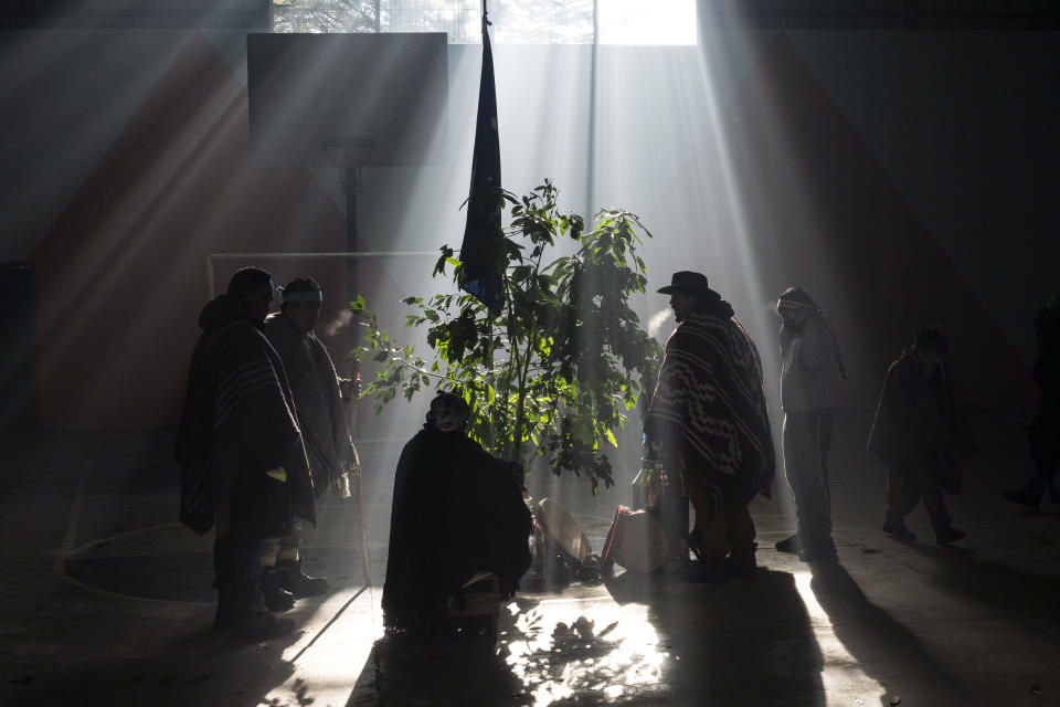 Teachers and students gather for a yeyipun, or Mapuche opening prayer, to greet, give thanks to and ask the forces of nature for good living inside their school in Carimallin, southern Chile, on Thursday, June 23, 2022. Some 85% of the 125 kids attending in pre-K through 8th grade are Mapuche, according to Gerson López, who has been a teacher there for a decade. Only half of them are involved in the different Indigenous communities, he says but they all love celebrations of We Tripantu, the Mapuche new year. (AP Photo/Rodrigo Abd)