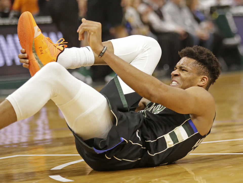 Milwaukee Bucks' Giannis Antetokounmpo grabs his foot during the first half of an NBA basketball game against the Miami Heat, Friday, March 22, 2019, in Milwaukee. (AP Photo/Jeffrey Phelps)