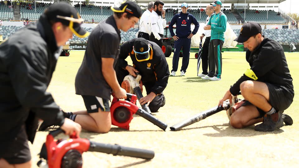 Ground staff work to dry out the WACA pitch. Pic: Getty