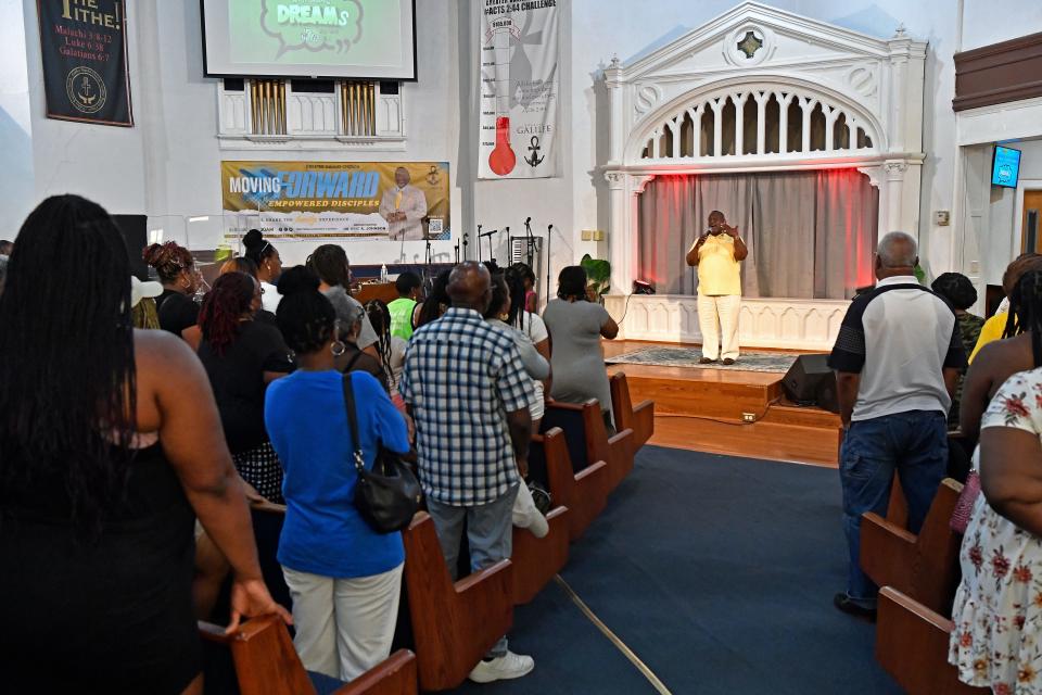 Pastor Eric Johnson, shown speaking to family and friends of his summer program, says "West Louisville does not have enough serious economic drivers."