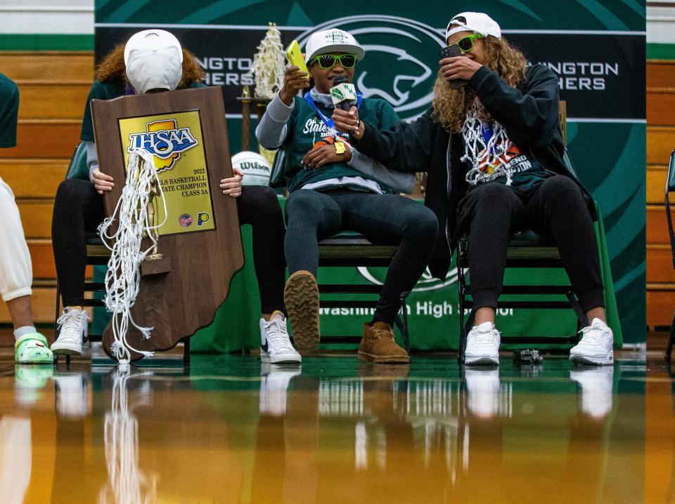 Amiyah Reynolds (1), from left, Rashunda Jones (2) and Mila Reynolds (15) share a laugh during a welcome home celebration for the state-title winning girls basketball team Sunday, Feb. 27, 2022 at Washington High School.