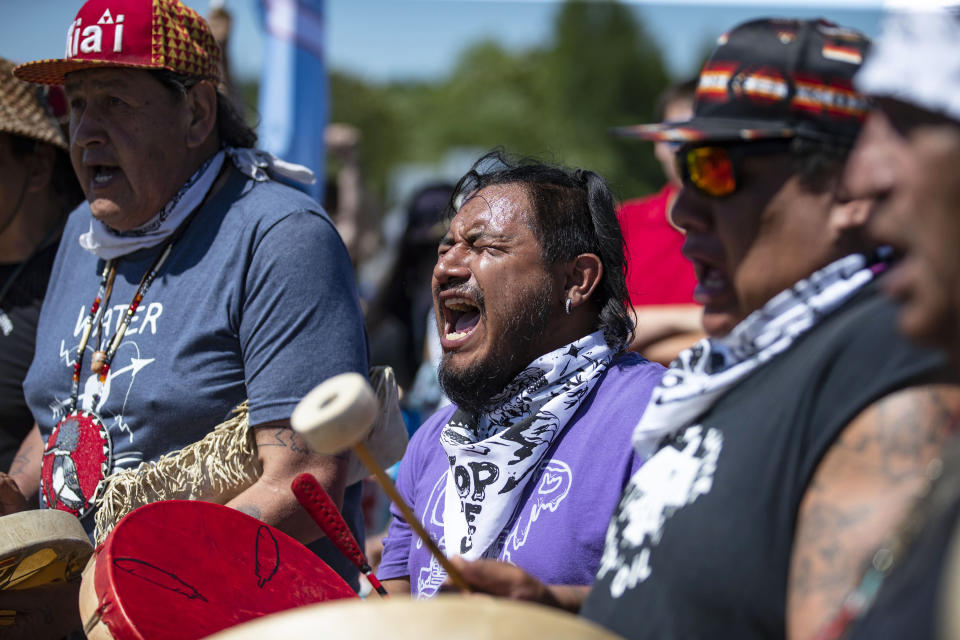 Jesse Barrientez, aka Red Feather, center, plays the drums and sings tribal songs with other Indigenous people during a march, on Monday, June 7, 2021, in Clearwater County, Minn. More than 2,000 Indigenous leaders and "water protectors" gathered in Clearwater County from around the country to protest the construction of Enbridge Line 3. The day started with a prayer circle and moved on to a march to the Mississippi headwaters where the oil pipeline is proposed to be built. (Alex Kormann/Star Tribune via AP)