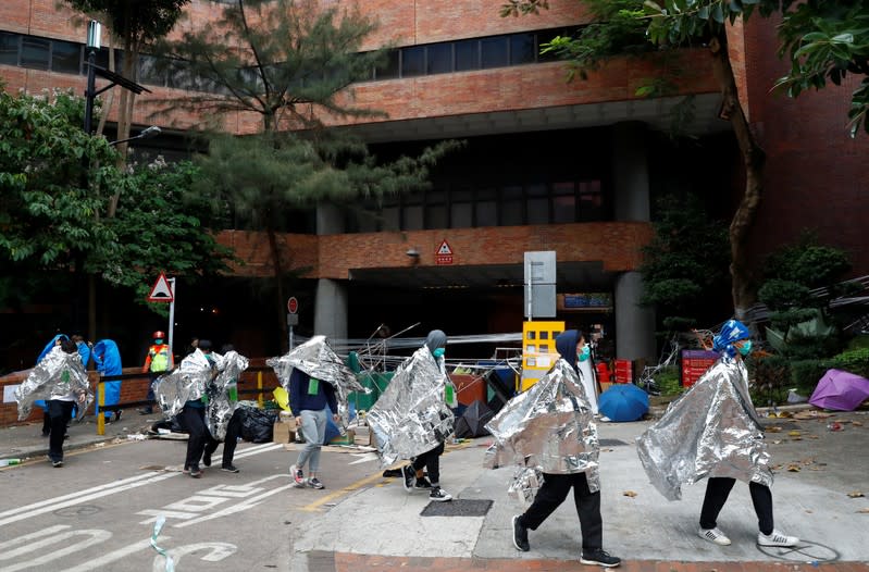 Protesters leave the Hong Kong Polytechnic University campus to surrender to police, in Hong Kong