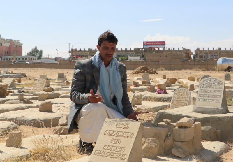 Osama Ezzi al-Ghaili, 29, recites prayers next to a grave of a family member killed in an air strike, at a grave yard in Saada