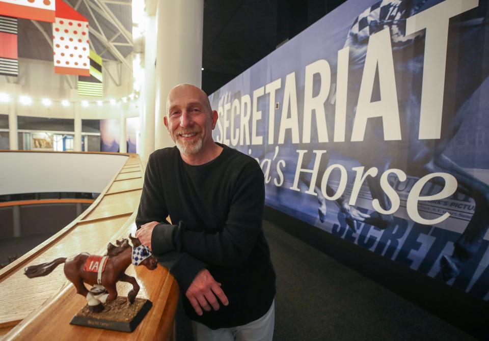 Leonard Lusky poses in the Secretariat exhibit at the Kentucky Derby Museum on Thursday, April 6, 2023.  He helped to develop and bring to market the Secretariat bobblehead the he is posing with.