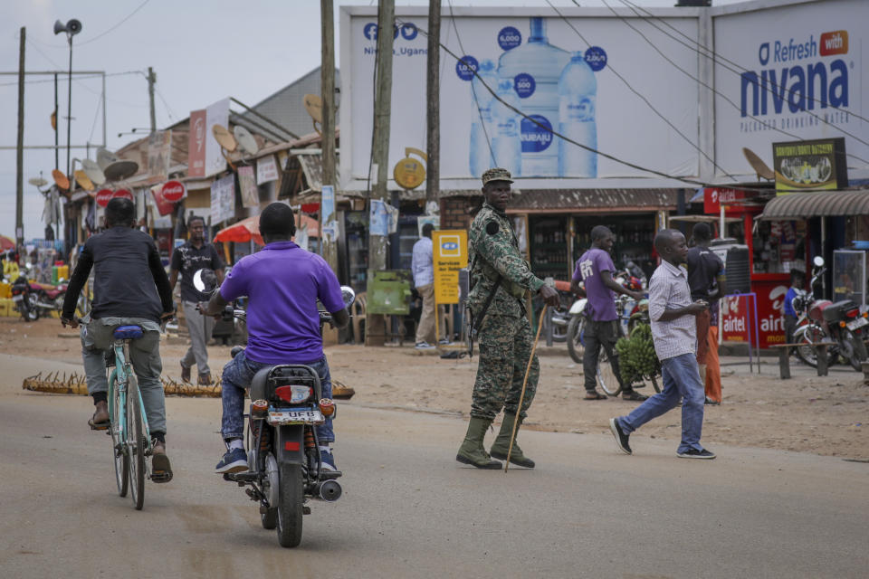 A military officers observes traffic at a checkpoint set up to stop motorcycles carrying passengers, in an attempt to limit the spread of Ebola, in Mubende, Uganda Tuesday, Nov. 1, 2022. Ugandan health officials say they have controlled the spread of a strain of Ebola that has no proven vaccine, but there are pockets of resistance to health measures among some in rural communities where illiteracy is high and restrictions on movement and business activity have left many bitter. (AP Photo/Hajarah Nalwadda)