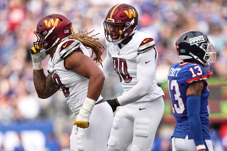 Chase Young and Montez Sweat of the Washington Commanders celebrate after a fumble recovery in the fourth quarter of the game against the New York Giants at MetLife Stadium on October 22, 2023 in East Rutherford, New Jersey.