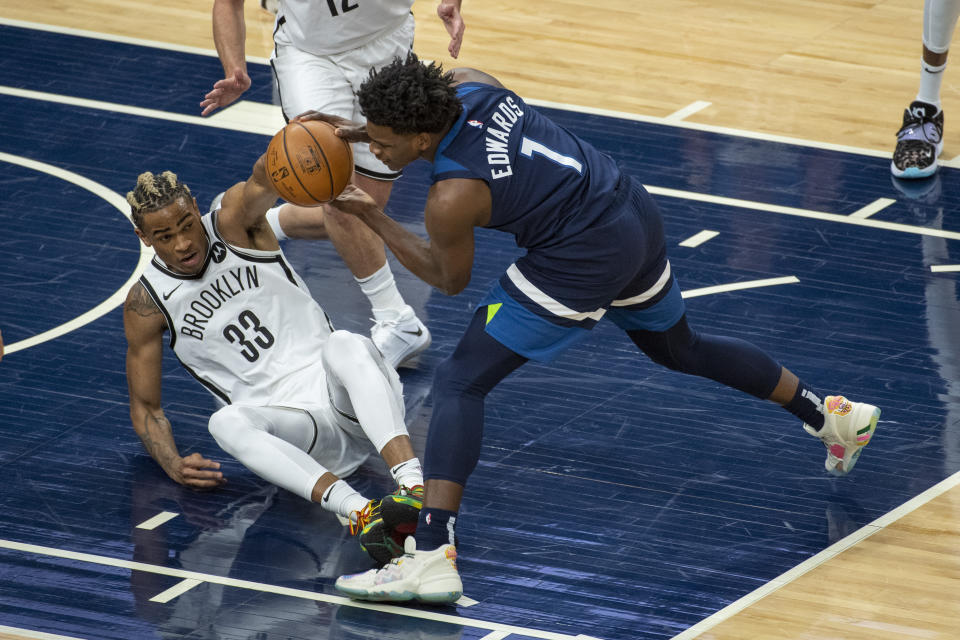 Minnesota Timberwolves guard Anthony Edwards (1) and Brooklyn Nets forward Nicolas Claxton (33) battle for a loose ball during the first half of an NBA basketball game Tuesday, April 13, 2021, in Minneapolis. (AP Photo/Craig Lassig)