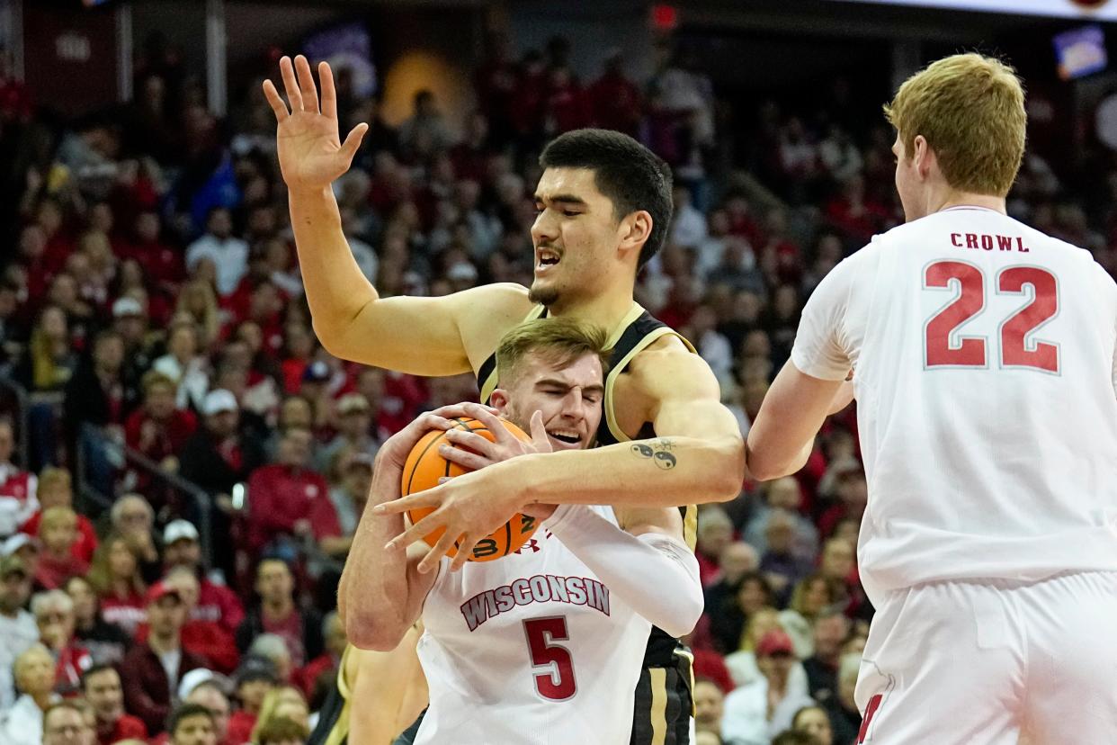 Wisconsin's Tyler Wahl (5) grabs a loose ball away from Purdue's Zach Edey (15) during the first half of an NCAA college basketball game Sunday, Feb. 4, 2024, in Madison, Wis. (AP Photo/Andy Manis)