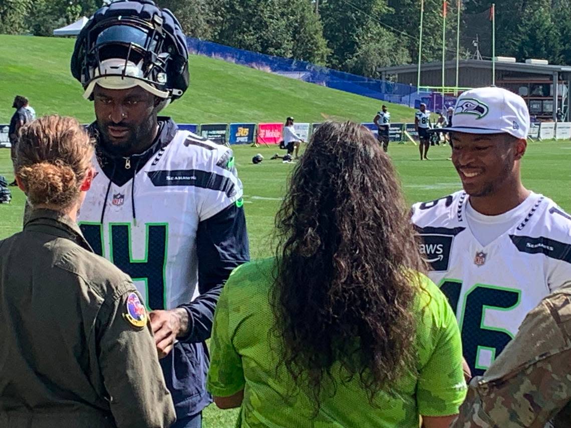 Seahawks receivers DK Metcalf (14, left) and Tyler Lockett (16, right) talk with and sign autographs for service members in the U.S. Air Force’s 313th Airlift Squadron from Joint Base Lewis-McChord who visited training camp at the Virginia Mason Athletic Center in Renton Tuesday, Aug. 6, 2024.