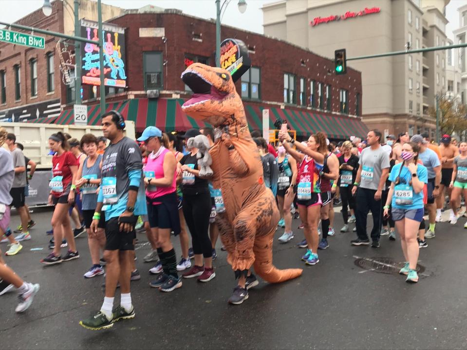 A runner dressed as a dinosaur prepares to start the St. Jude Memphis Marathon Saturday, December 4, 2021.