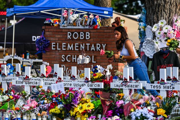 A girl lays flowers at a makeshift memorial at Robb Elementary School in Uvalde, Texas, on May 28, 2022. (Photo: CHANDAN KHANNA via Getty Images)