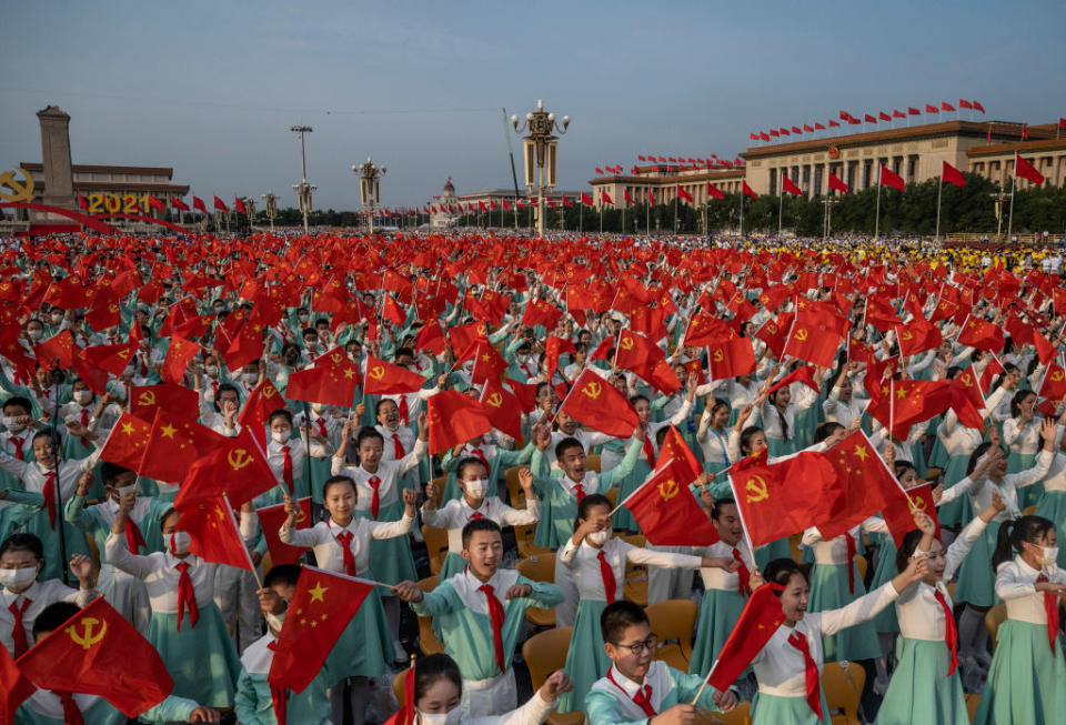 Chinese students wave party and national flags at the 100th anniversary ceremony.